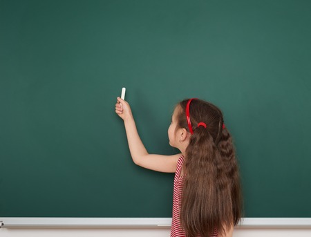 Schoolgirl write on the school boardの写真素材