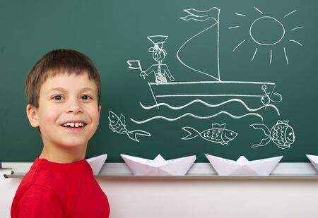 boy drawing ship on school boardの写真素材
