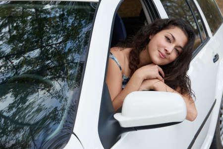 girl inside white car looking outの写真素材