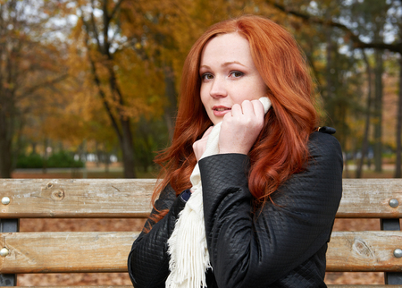 redhead girl portrait in city park, fall season