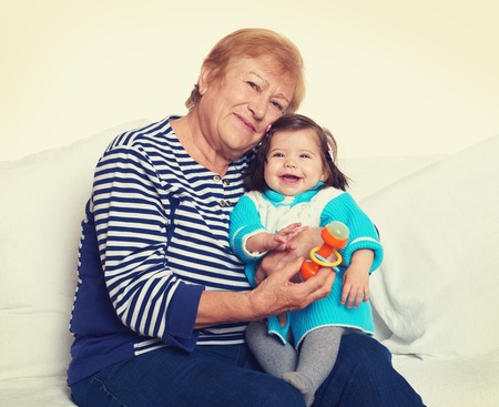 portrait of baby girl and grandmother on white, happy family conceptの写真素材