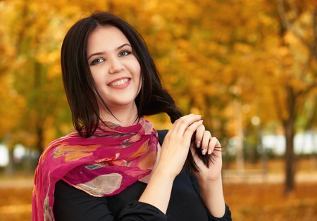 beautiful girl in black dress and red scarf in yellow city park, fallの写真素材