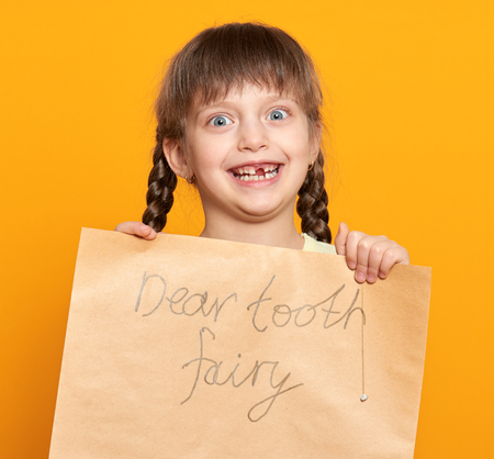lost tooth girl portrait, studio shoot on yellow backgroundの写真素材