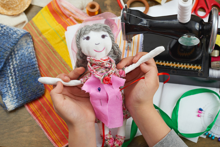 boy tailor learns to sew, dress for doll, handmade and handicraft conceptの写真素材