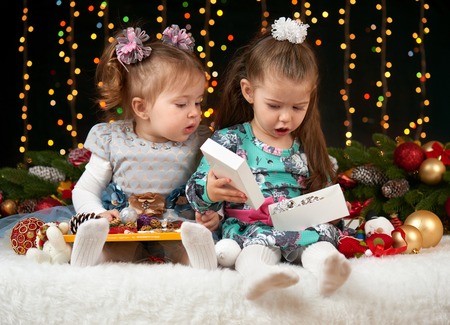 child girl portrait in christmas decoration, happy emotions, winter holiday concept, dark background with illumination and boke lightsの写真素材