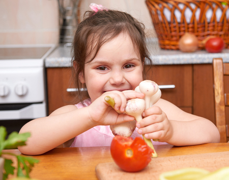 Children at the table with with fresh fruits and vegetables, home kitchen interior, healthy food conceptの写真素材
