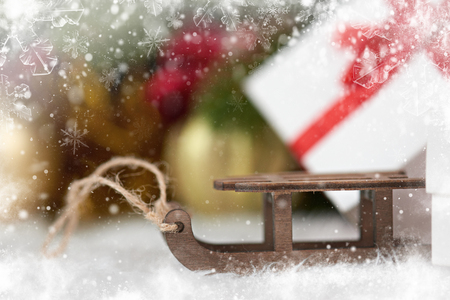 toy sleigh and Christmas decorations as background, decorated with snowの写真素材