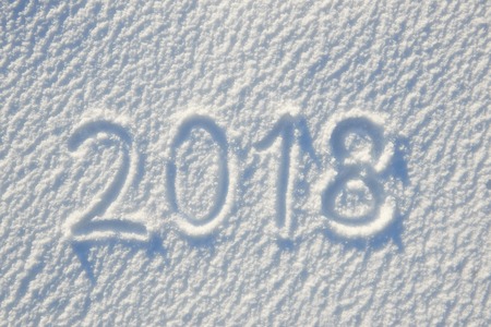 2018 text written on snow for texture or background - winter holiday concept. Sunny day, bright...