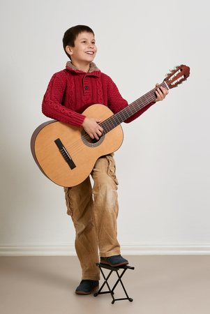 Boy posing with acoustic guitarの写真素材