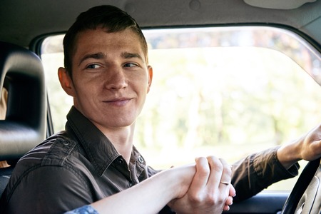 a man sitting in a car kissing a girl's hand, romantic feelings and love