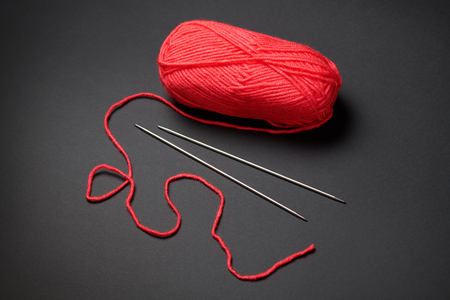 Red ball of woolen thread for knitting on black backgroundの写真素材