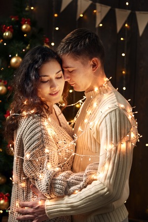 young couple posing with christmas decoration and lights