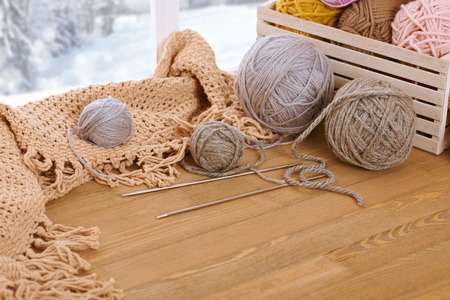 Woolen yarn and fabric on the window sill. Beautiful view outside the window - winter scenery and...