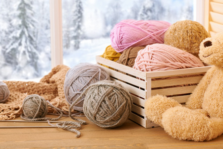 Woolen yarn and fabric on the window sill. Beautiful view outside the window - winter scenery and snow.の写真素材