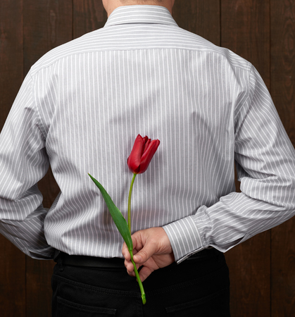 Man hides behind one red flowerの写真素材