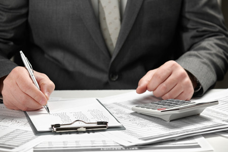 Businessman working in an office. Hands and documents closeup.の写真素材