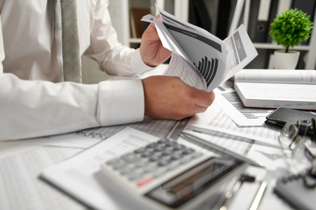 Businessman working at office and calculating finance, reads and writes reports. Business financial accounting concept.の写真素材