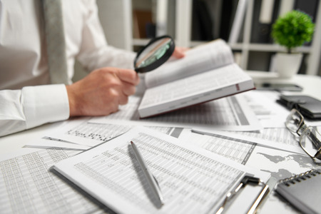 Businessman working at office and calculating finance, reads and writes reports. Business financial accounting concept.の写真素材