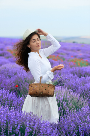 young woman is in the lavender flower field, beautiful summer landscapeの写真素材