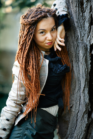 happy dreadlocks fashionable girl posing in forestの写真素材