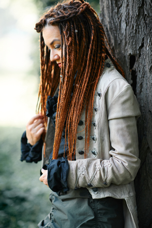 happy dreadlocks fashionable girl posing in forest