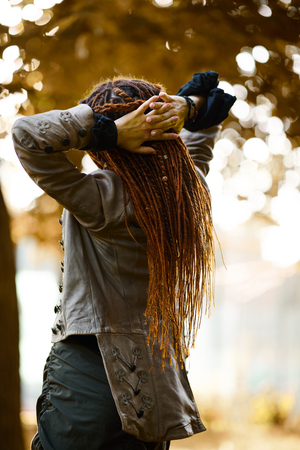 happy dreadlocks fashionable girl posing in sunny forestの写真素材