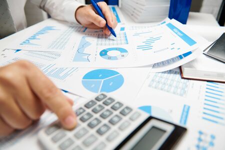 Businessman working and calculating, reads and writes reports. Office employee, table closeup....