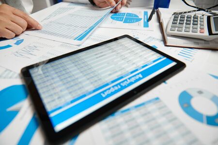 Businessman working and calculating, reads and writes reports. Using tablet pc. Office employee, table closeup. Business financial accounting concept.の写真素材