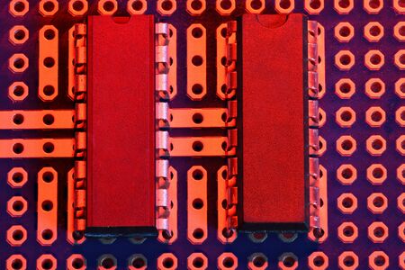 printed circuit board and microchip in red light closeup - electronic component for digital...