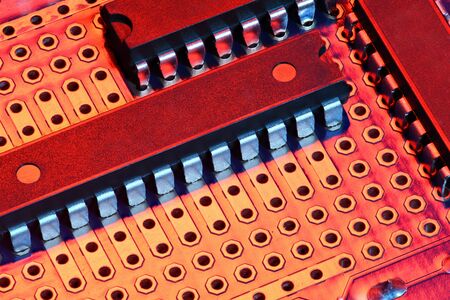 printed circuit board and microchip in red light closeup - electronic component for digital...
