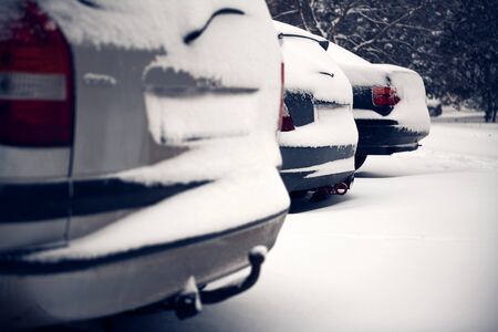 Cars covered by snow on street in winter dayの写真素材
