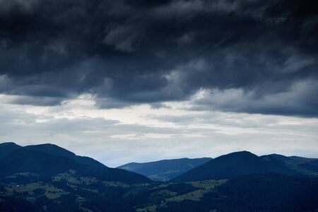 Sunset in carpathian mountains - beautiful summer landscape, spruces on hills, cloudy sky and...