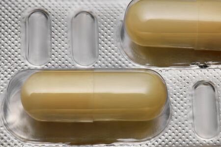 Brown capsules pill in blister pack arranged with beautiful pattern. Global healthcare concept....