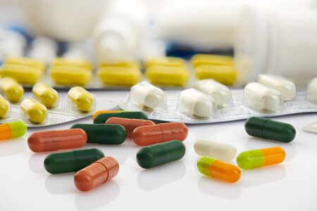 Various tablets, pills and vitamins in blister pack on white background. Global healthcare concept. Antibiotics drug resistance. Antimicrobial capsule pills. Pharmaceutical industry. Pharmacy.の写真素材
