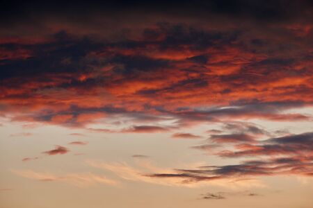 beautiful dramatic sky with dark and bright clouds at sunset, summer landscape, golden sunlight