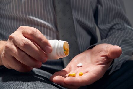 businessman with a pill, hands close view - concept of difficulties, depression, problems, health...