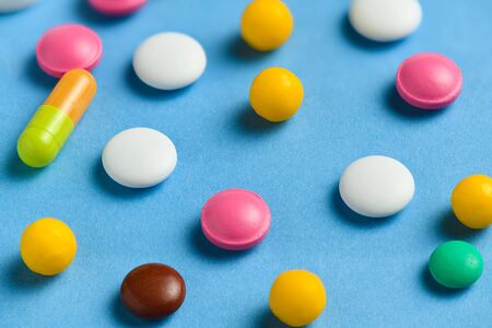Pills, tablets, vitamins, drugs, medicine macro photo on blue background