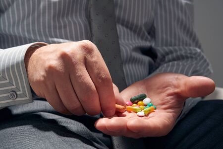 businessman with a pill, hands close view - concept of difficulties, depression, problems, health...