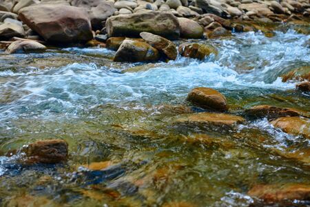landscape, beautiful view of mountain river in summer day, fast flowing water and rocks, wild nature
