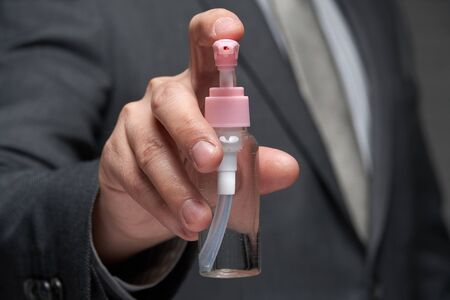 a man demonstrates a protective face mask for antivirus individual protection and bottle of sanitizer liquid- healthcare and medicine concept, prevention tipsの写真素材