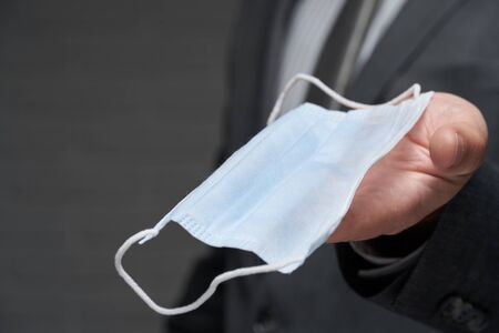 a man demonstrates a protective face mask for antivirus individual protection - healthcare and medicine concept, prevention tipsの写真素材