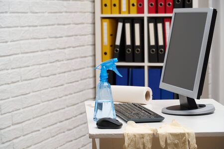 concept of cleaning or disinfecting the office - a businessman cleans the workplace, computer, desk,...