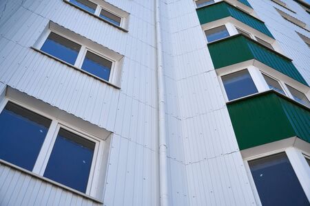 facade of a new multi-storey building with white and green metal siding, many Windowsの写真素材