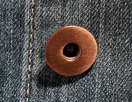 a brass button with jeans natural clean background macro photo, dark blue pattern texture, design...