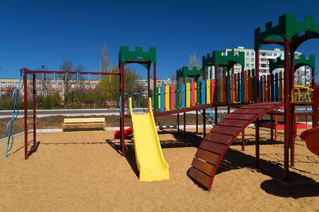 Empty urban residential infrastructure, nobody - children's playground next to a condominium. Swing,...