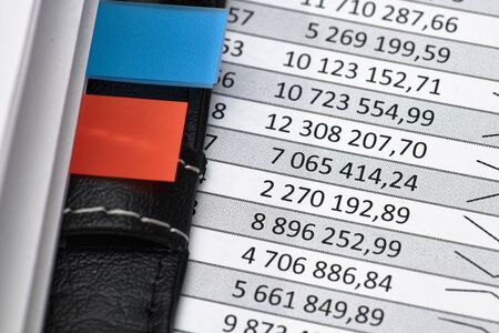 Top view of office worker's desk - work with financial reports, analysis and accounting, tables and graphs, various office items for bookkeepingの写真素材