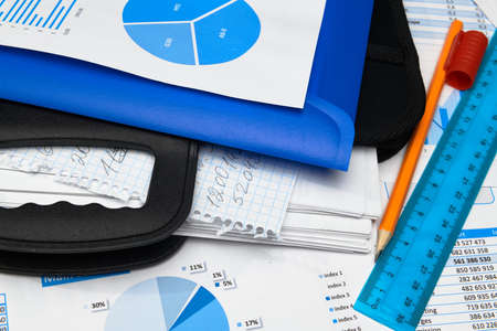 business office desk closeup - financial reports, analysis and accounting, set of documents, tables and graphs, various items for bookkeeping, calculatorの写真素材