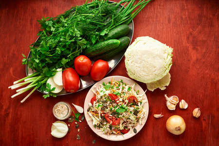 healthy food - fresh chopped vegetables on a wooden background, tomatoes and greensの写真素材