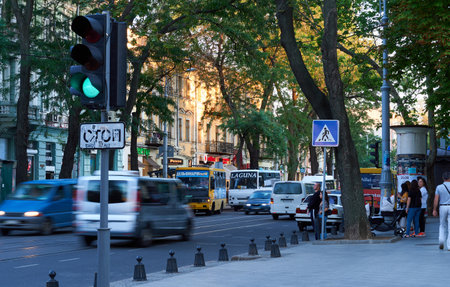 Odessa, Ukraine - August 4, 2020: Preobrazhenskaya street near the Cathedral square and city Park, green trees and people, road with car trafficのeditorial素材