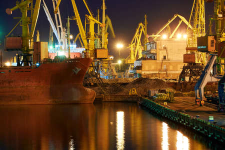 view of the industrial port at night - ships waiting for loading and unloading, cargo transportation...